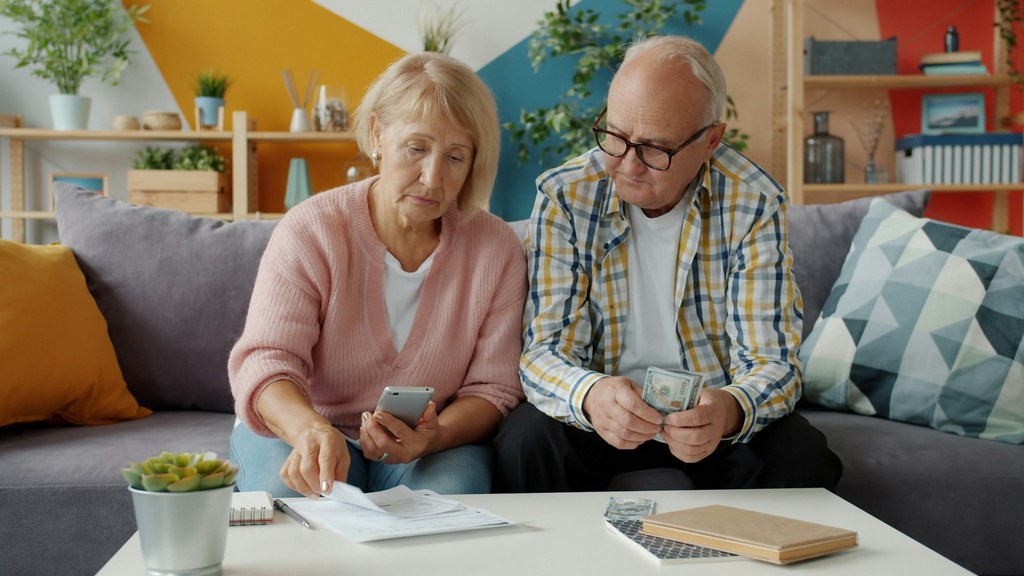 Couple de retraités suisses vérifiant leurs finances, illustrant l'impôt sur la fortune en Espagne